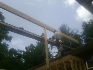 Carpenter setting a ridge beam over a new addition frame — Ice Dam Removal by Roofing Brothers in Higganum