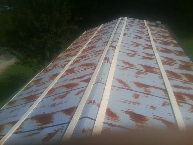 Rusted metal roof panels with new wood purlins before replacement — Storm Damage Roof Repair in Higganum by Roofing Brothers