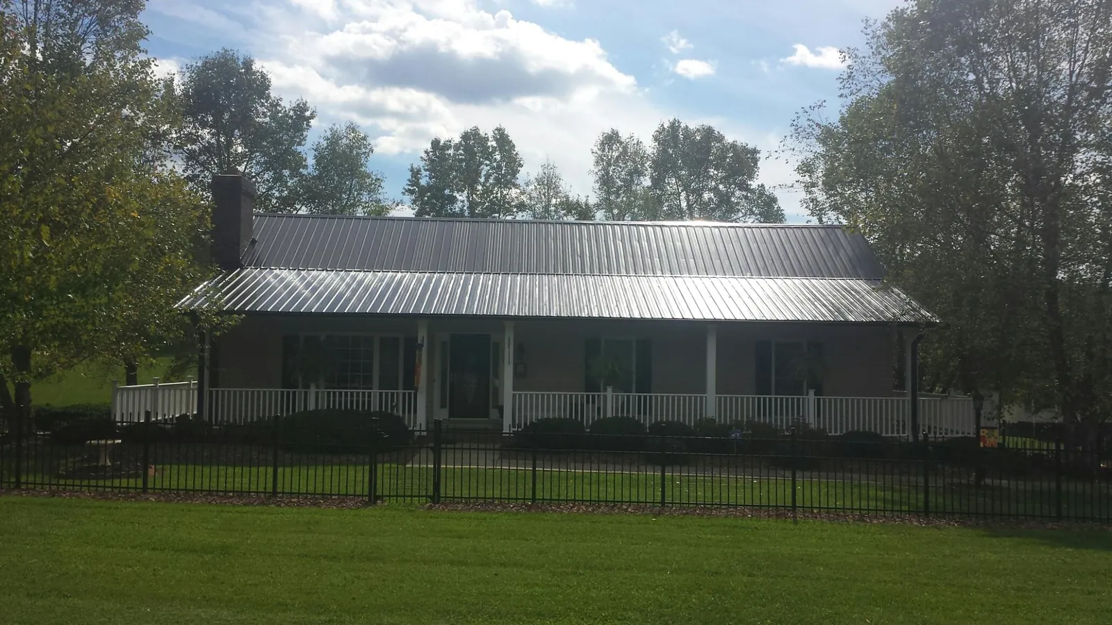 Gray metal roof on a brick ranch with a full width front porch — Gutter Guard Installation work by our crew in Higganum